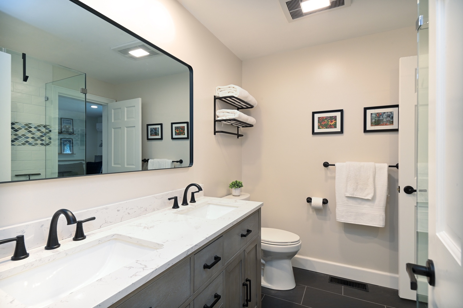 The stylish full bath showcases a double vanity & glass shower