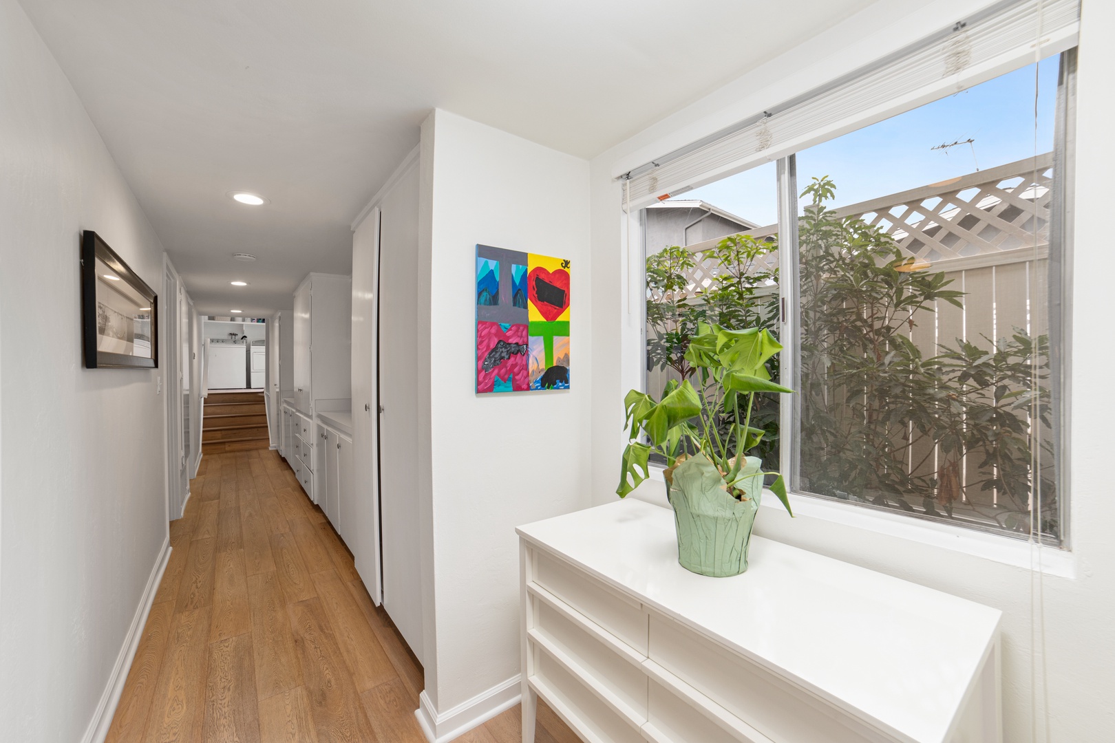 Bright hallway with ample storage, featuring vibrant & colorful artwork