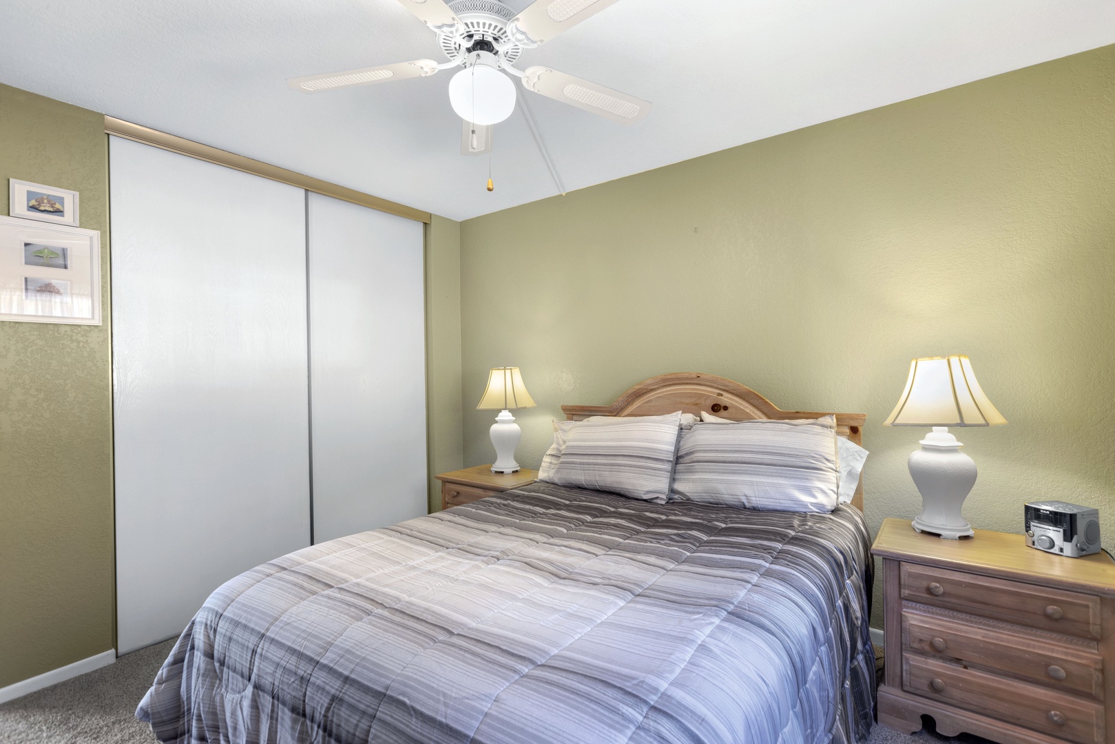 The master bedroom retreat showcases a plush queen bed, ceiling fan & smart TV