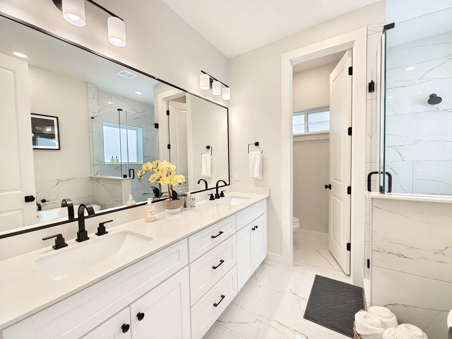 The master ensuite features a double vanity, glass shower, & soaking tub