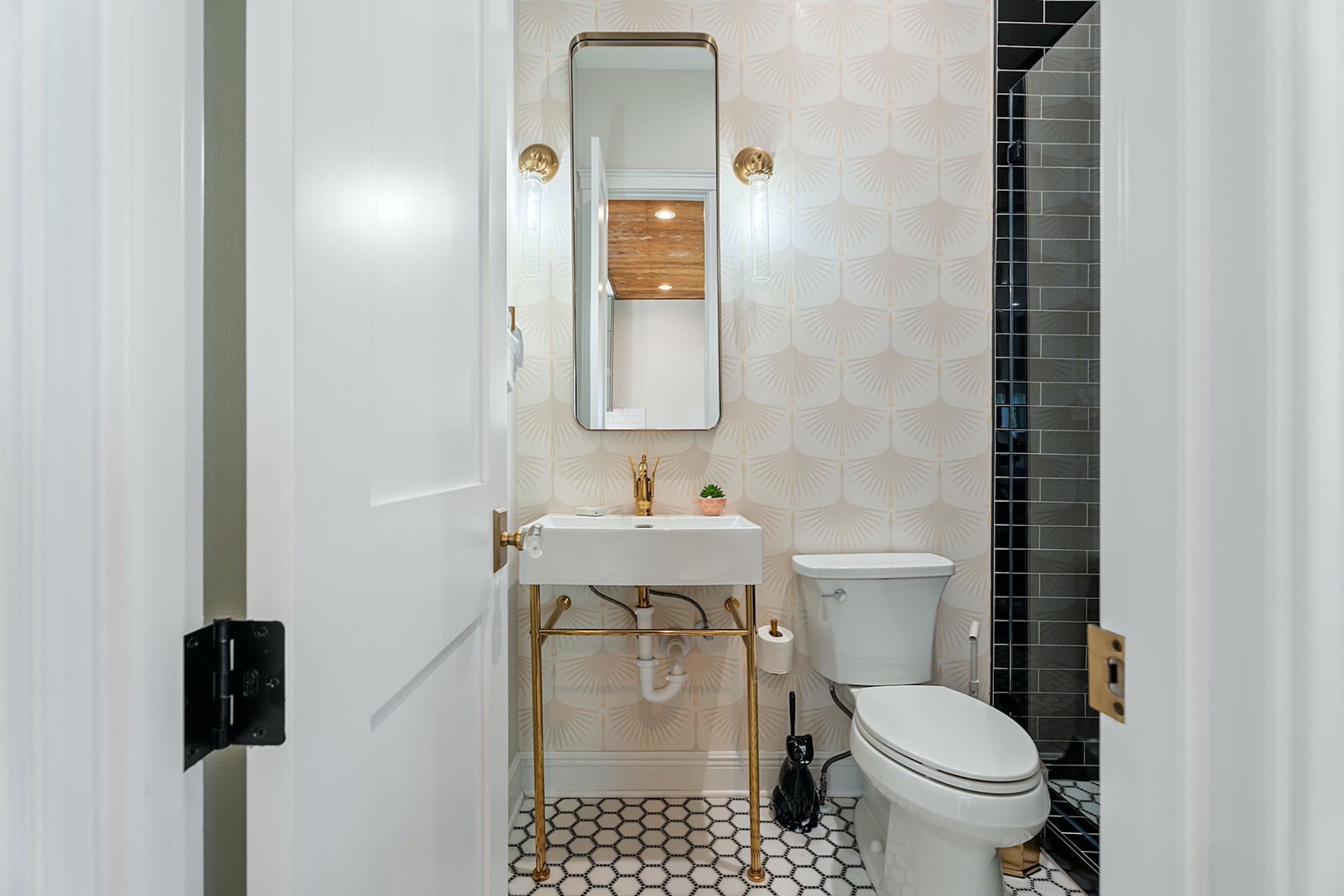 This full bathroom contains a pedestal sink & glass walk-in shower
