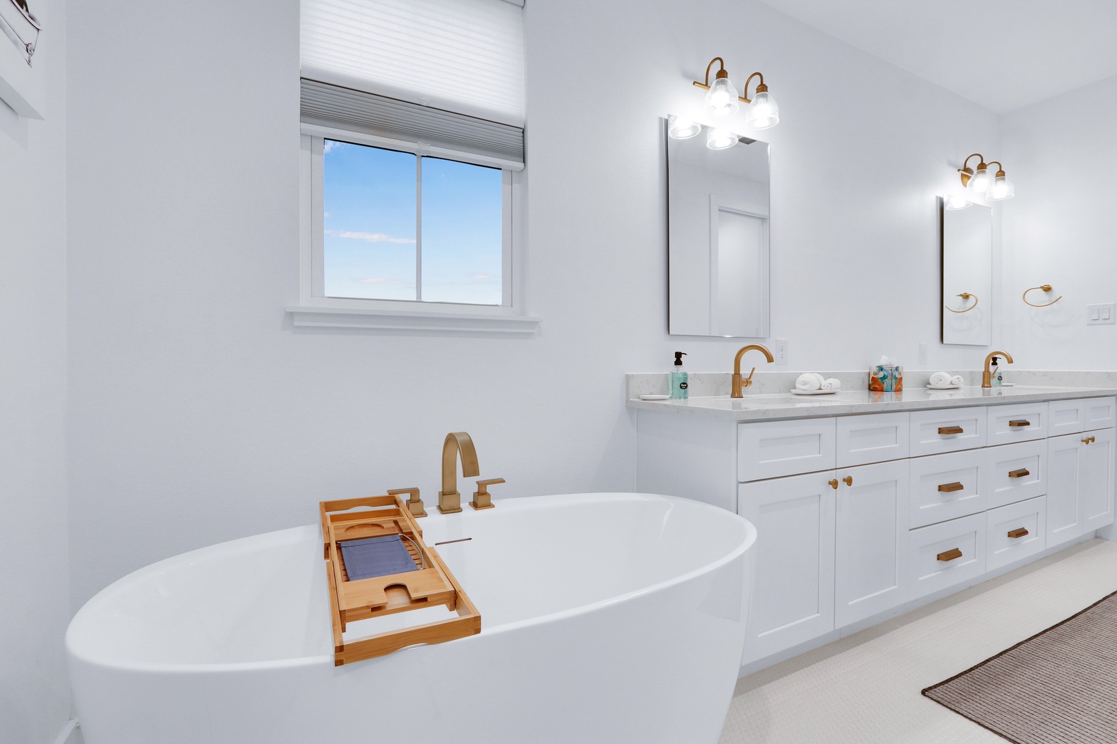 This chic ensuite features dual vanities, glass shower, & luxurious soaking tub