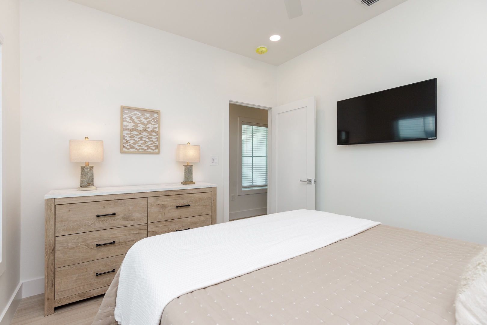 The serene queen bedroom on the first floor includes a Smart TV & dresser