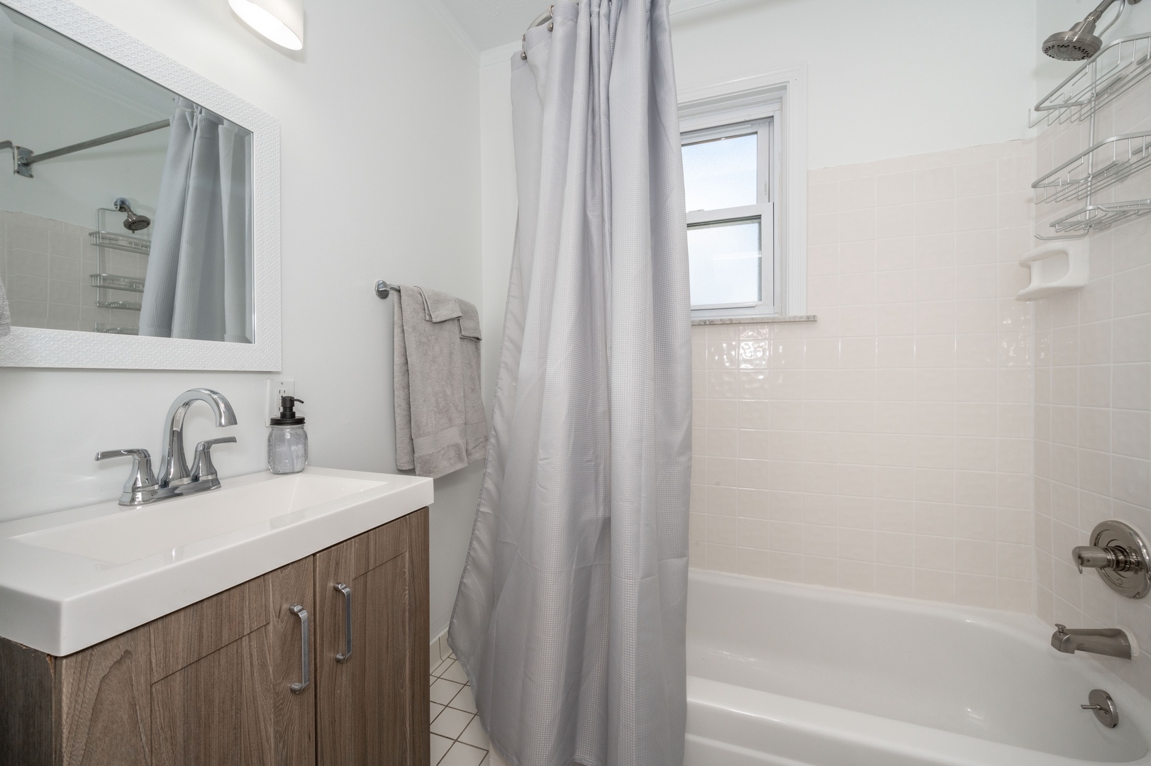 The main-level full bath offers a single vanity & shower/tub combo