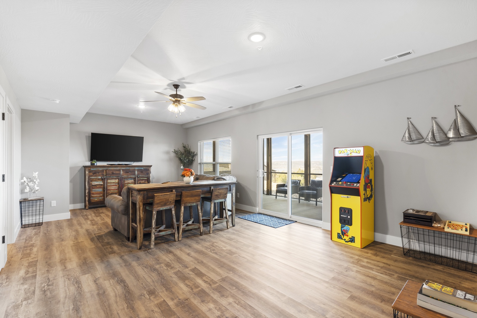 Basement game room with sofa sleeper, Smart TV, and bottom deck access