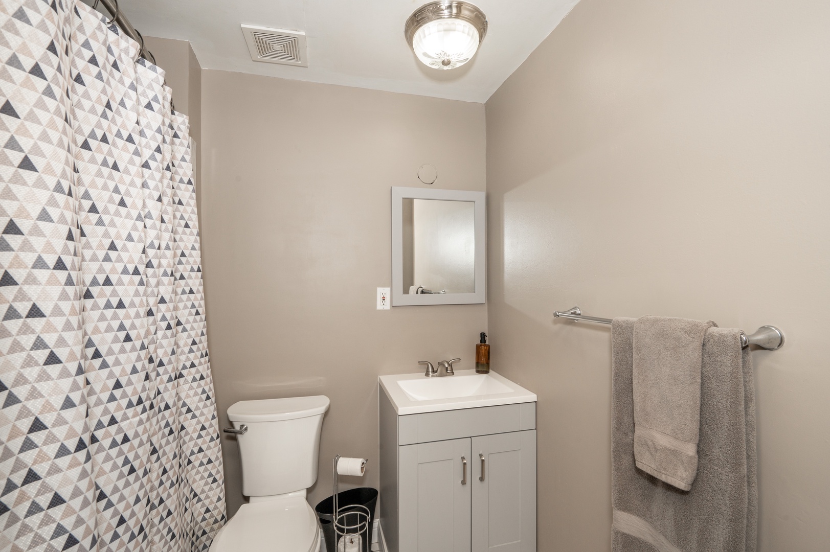 This condo’s full bathroom offers a single vanity & walk-in shower