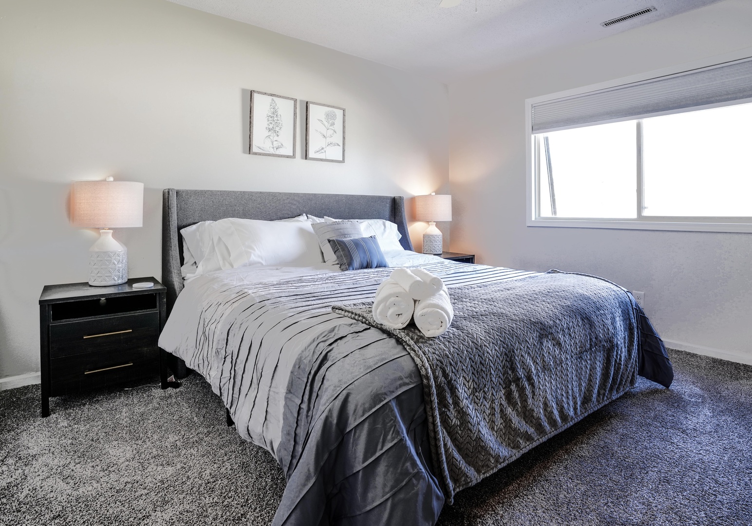 The first of two spacious bedrooms, boasting a plush king bed & Smart TV