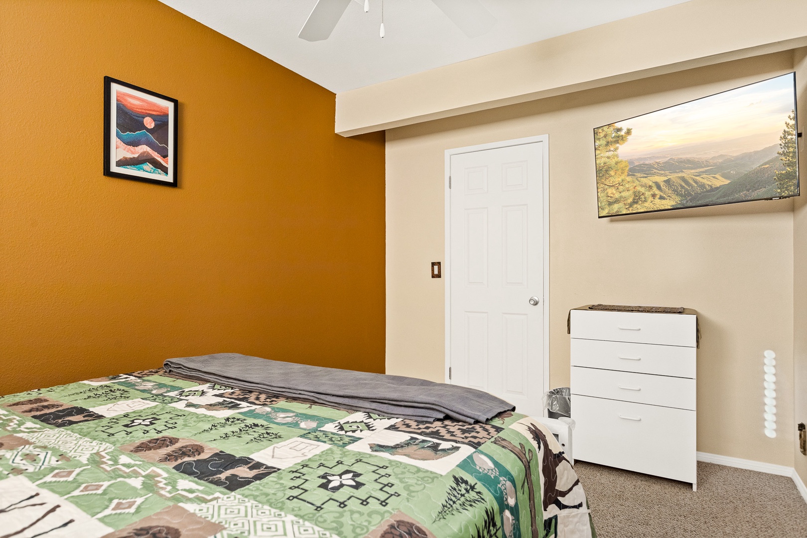 The 2nd of two bedrooms includes a queen bed, ceiling fan, & walk-in closet