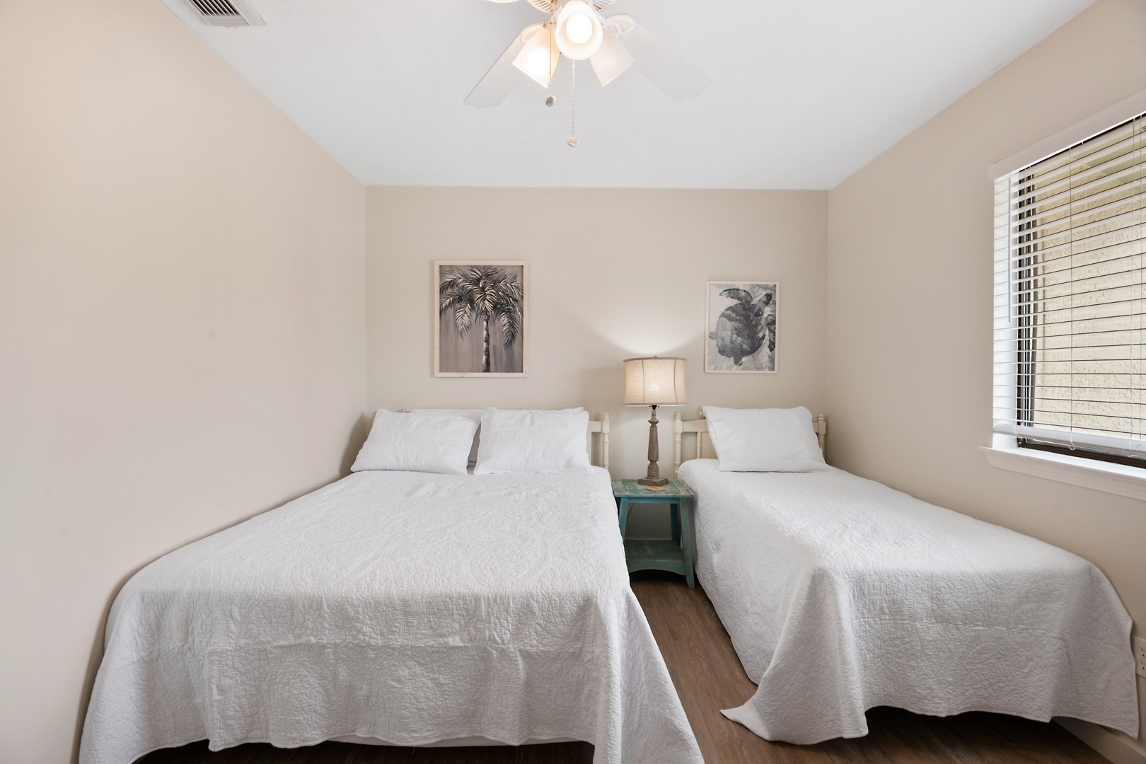 A queen bed, twin bed, & smart TV await in the second bedroom