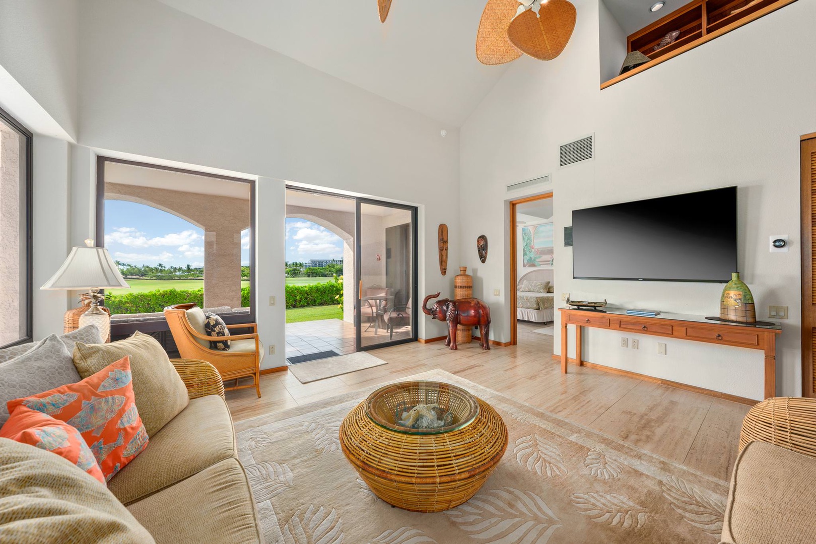 Tropical living room with 70" Smart TV, garden view and lanai access