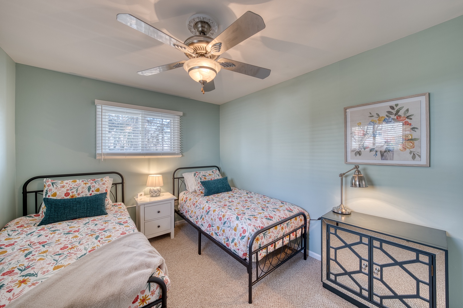 This charming bedroom retreat features a pair of plush twin beds