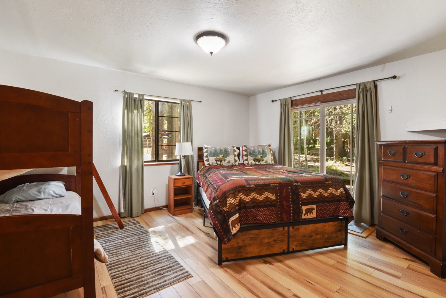 Bedroom 1 with queen bed, twin/twin bunk bed, and deck access