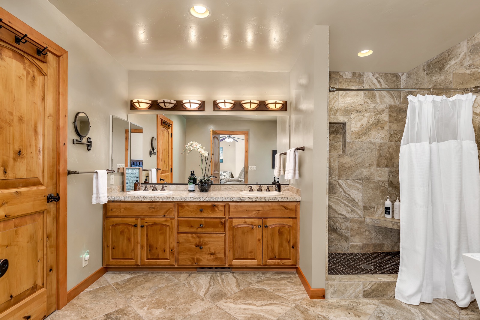 The main-level master en suite boasts a double vanity, shower, & soaking tub