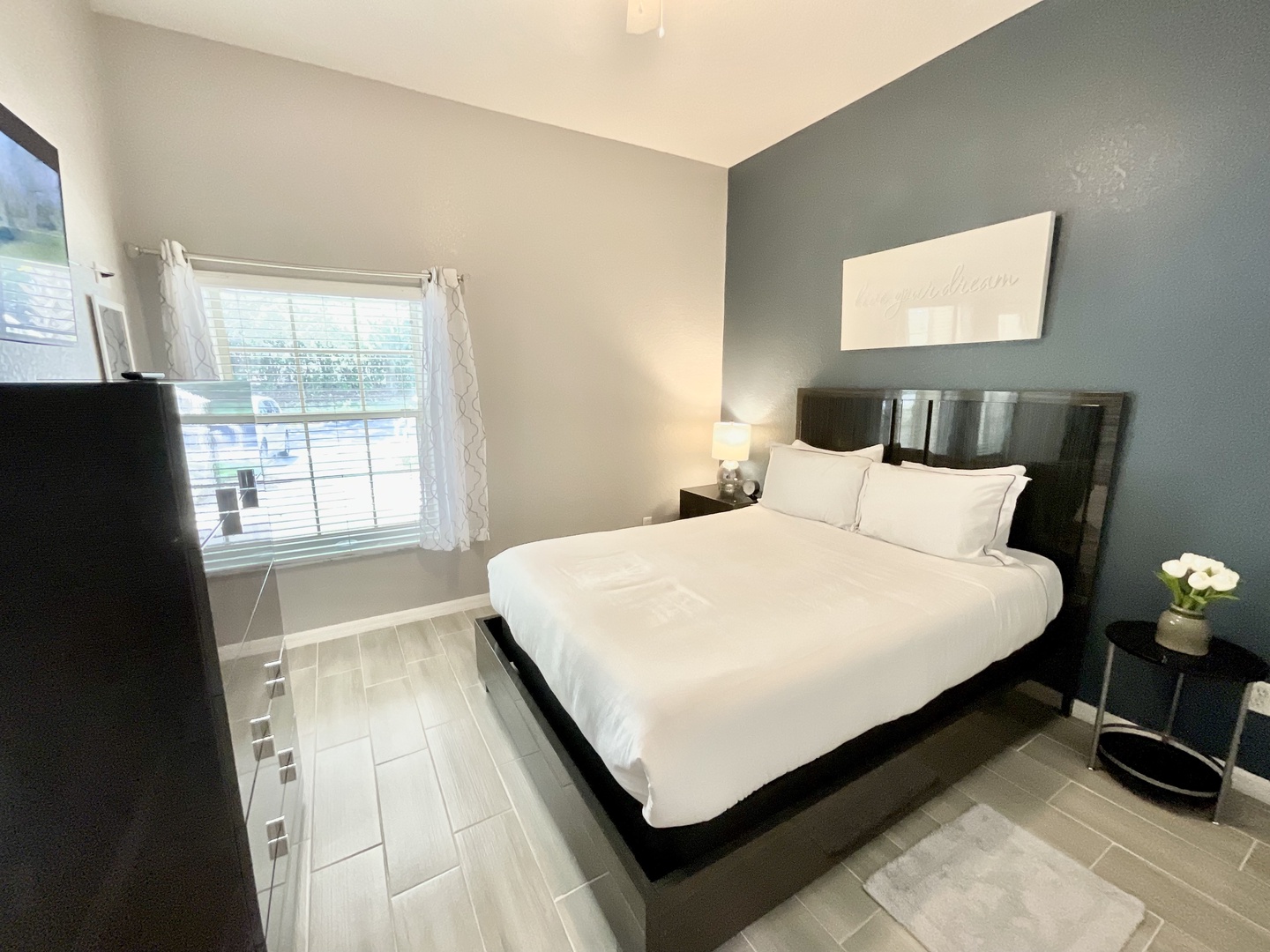 This chic queen bedroom includes a Smart TV & large dresser