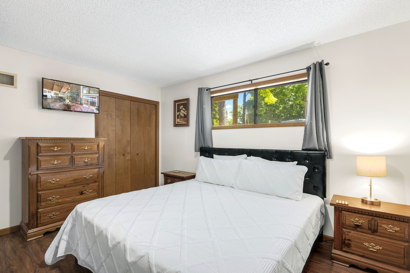 The 1st of 2 spacious main-level bedrooms, with a king bed & Smart TV