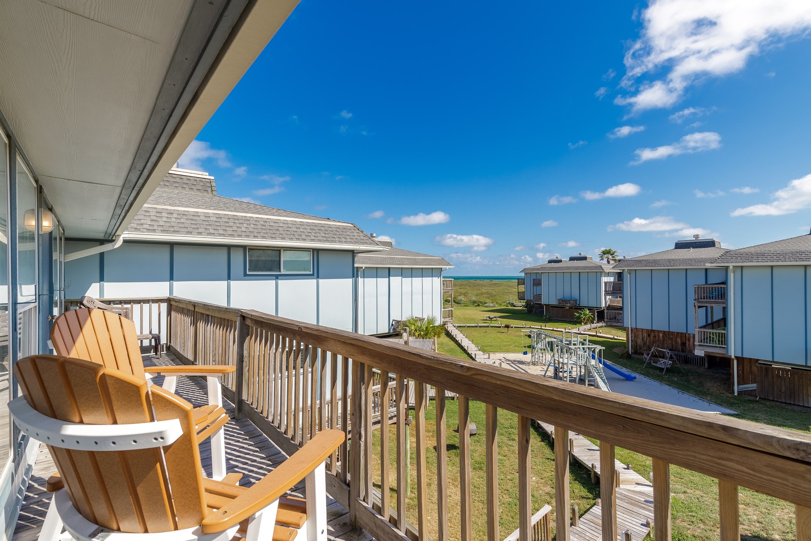 Expansive view of the ocean, dunes and playscape from the spacious deck