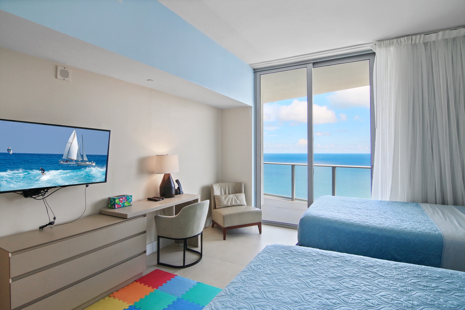 The 1st of 2 double queen bedrooms offers a Smart TV, desk, & balcony access