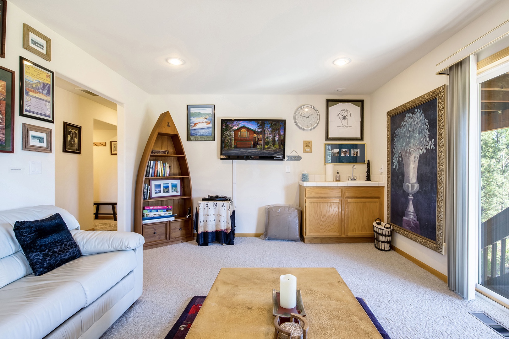 Additional living area on the bottom floor with balcony, seating, and TV