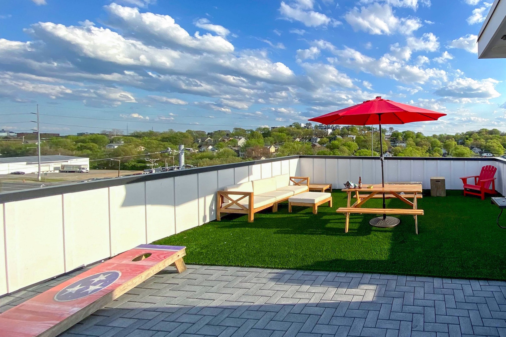 Rooftop lounge with cornhole, BBQ, Smart TV, fire pit, and plenty of seating