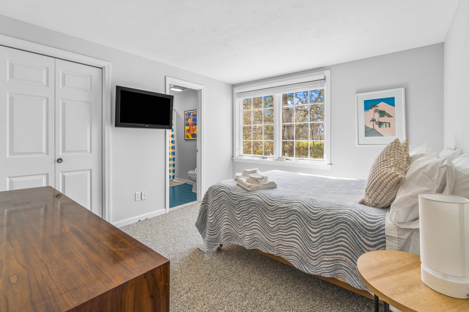 The primary suite boasts a plush full bed, ensuite bath, & Smart TV