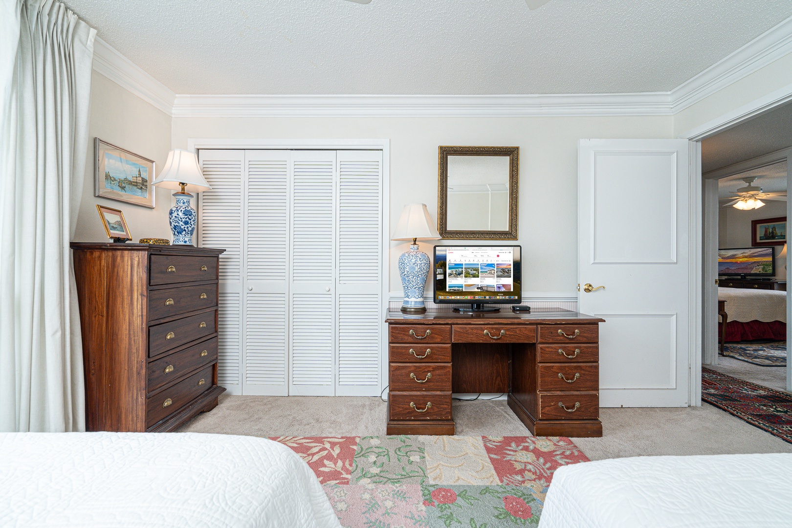 The second bedroom retreat offers two plush full beds, a TV, & beach views