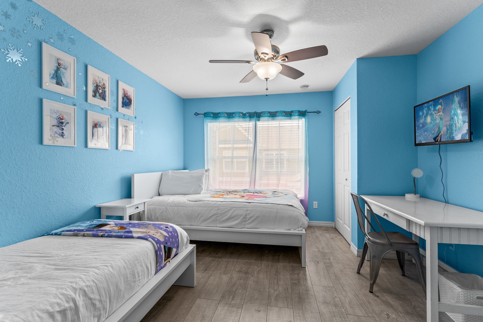 Cozy Frozen-themed bedroom with a full & twin bed, fan, & convenient desk