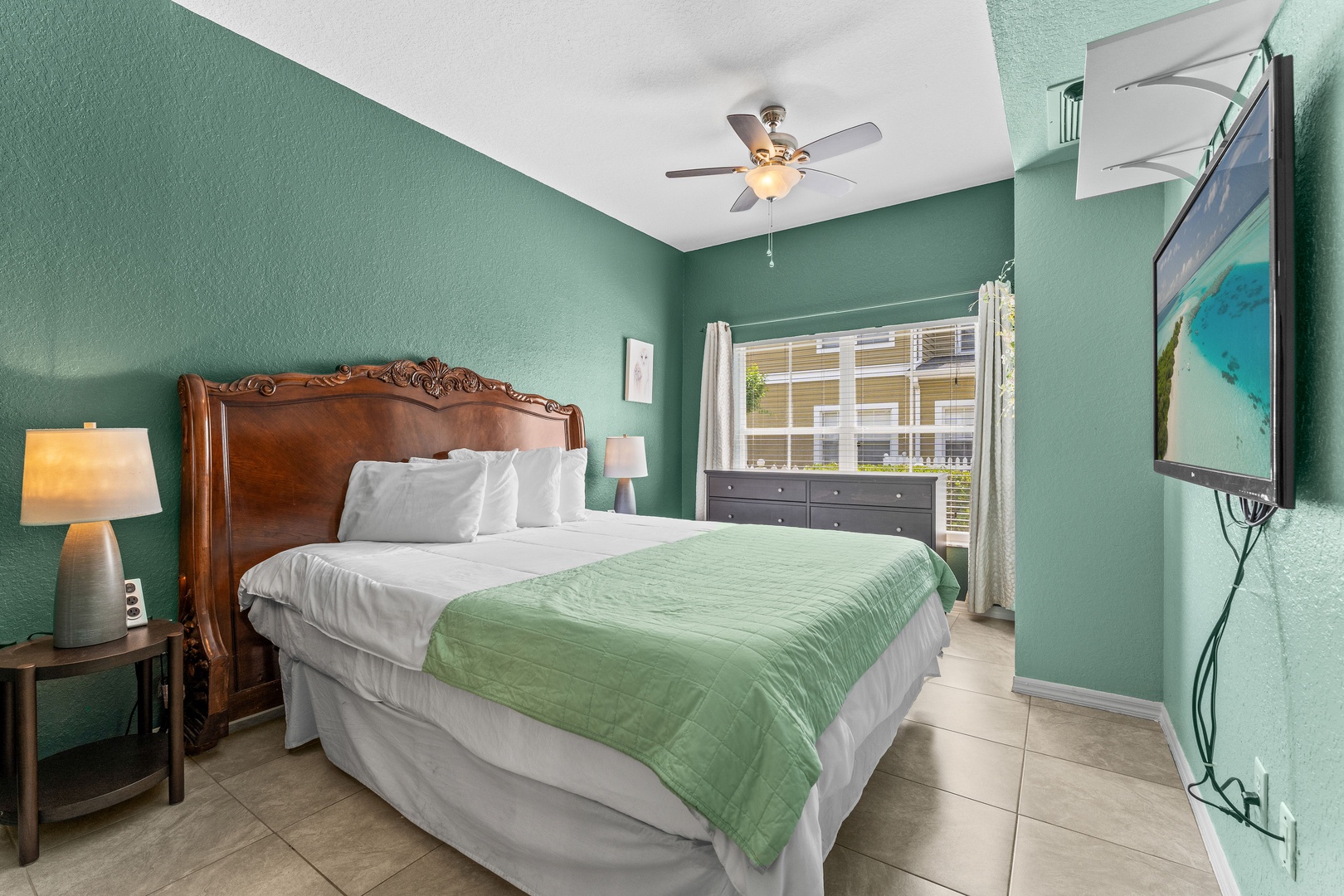 Spacious king bedroom with ensuite bathroom, smart TV, and ceiling fan
