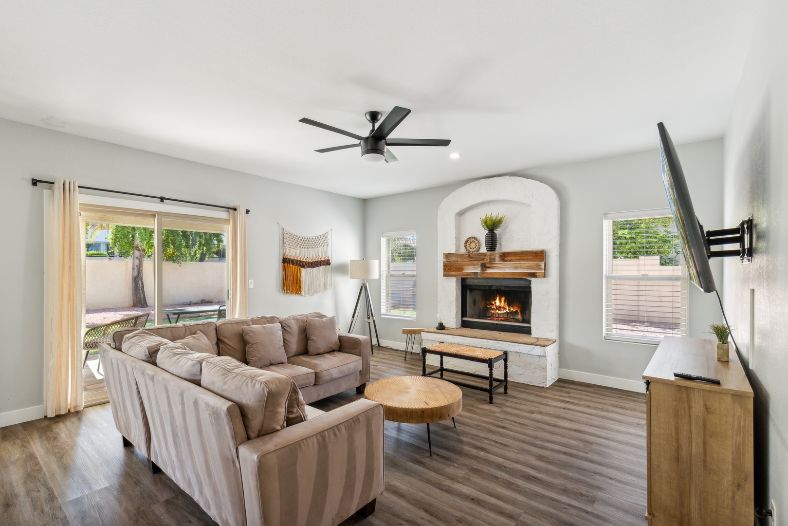 Living space off of the back yard with sectional sofa, fireplace, and Smart TV