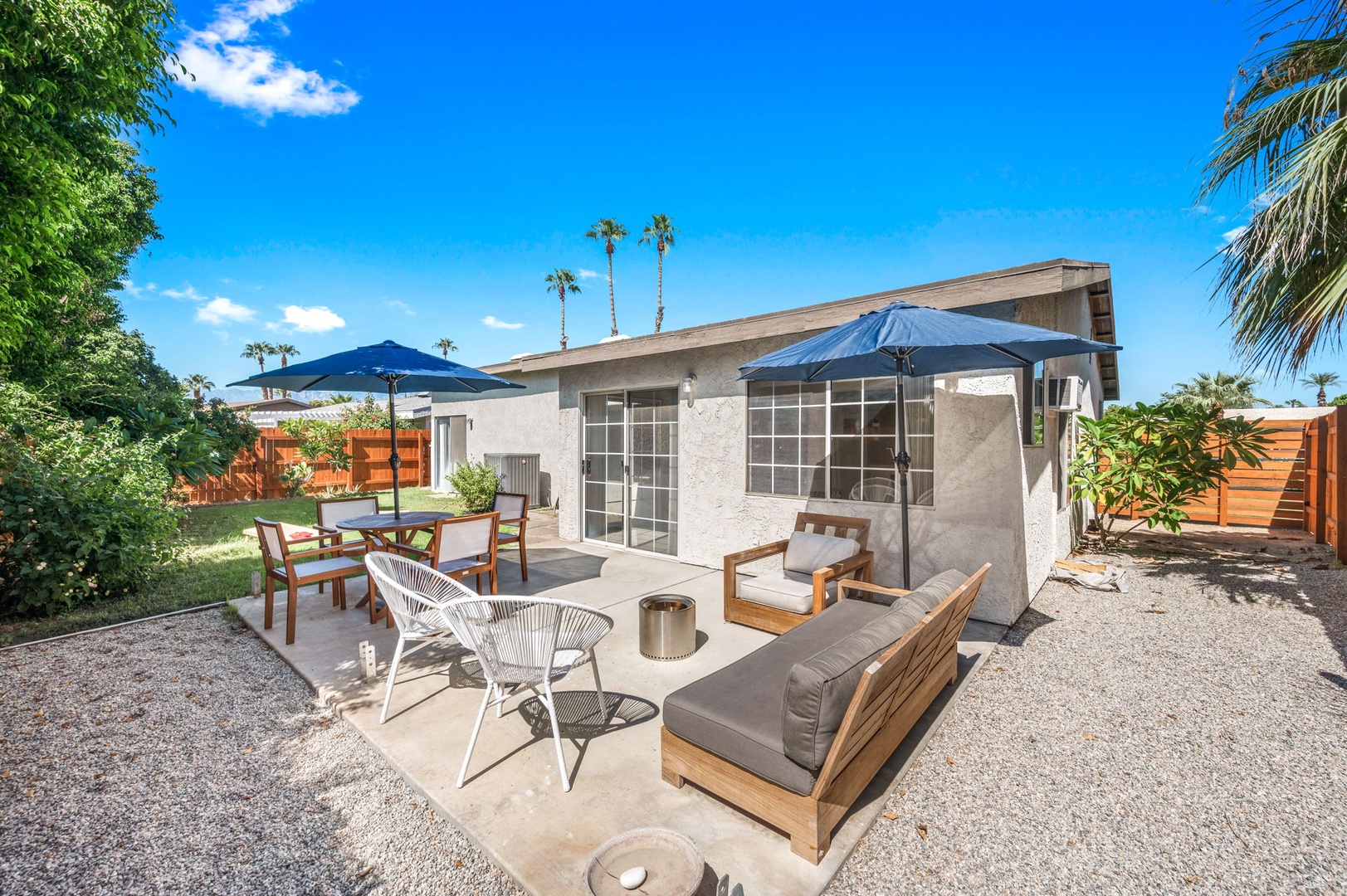 The fenced back yard offers space to lounge, grill, dine & play