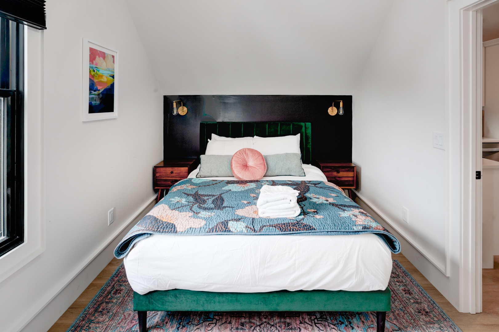The primary bedroom offers a regal queen-sized bed & desk workspace