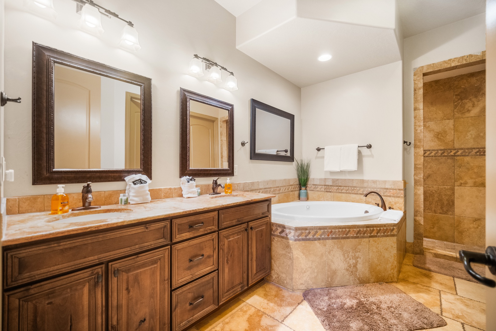 The primary ensuite showcases a dual sink, soaking tub & walk-in shower