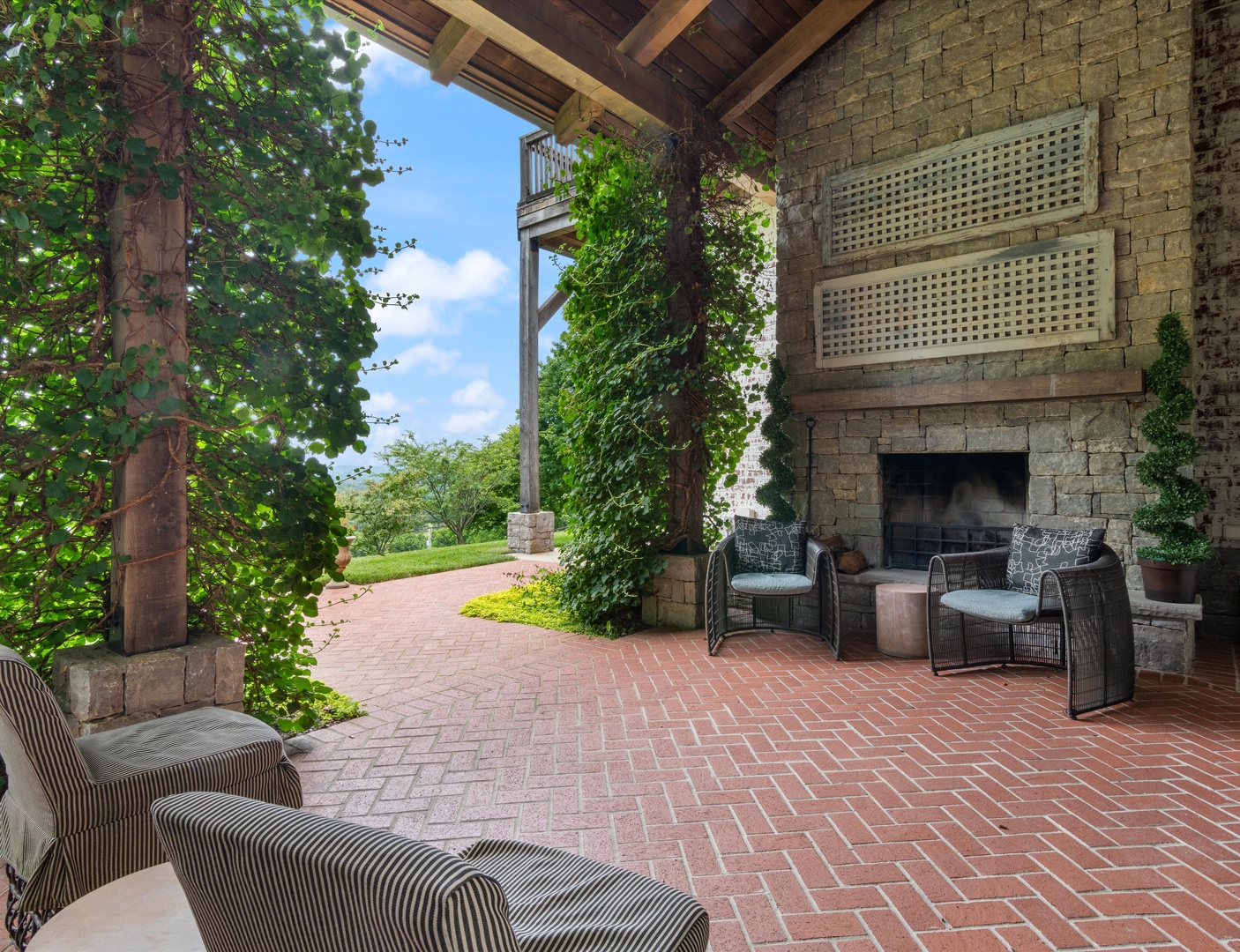 Relax in the serene outdoor living space with cozy seating and a stunning fireplace