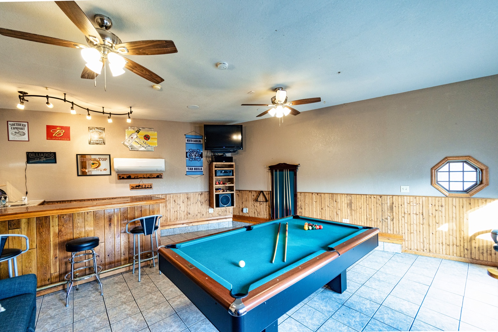 Game room with bar, convertible pool table, TV, and stereo system