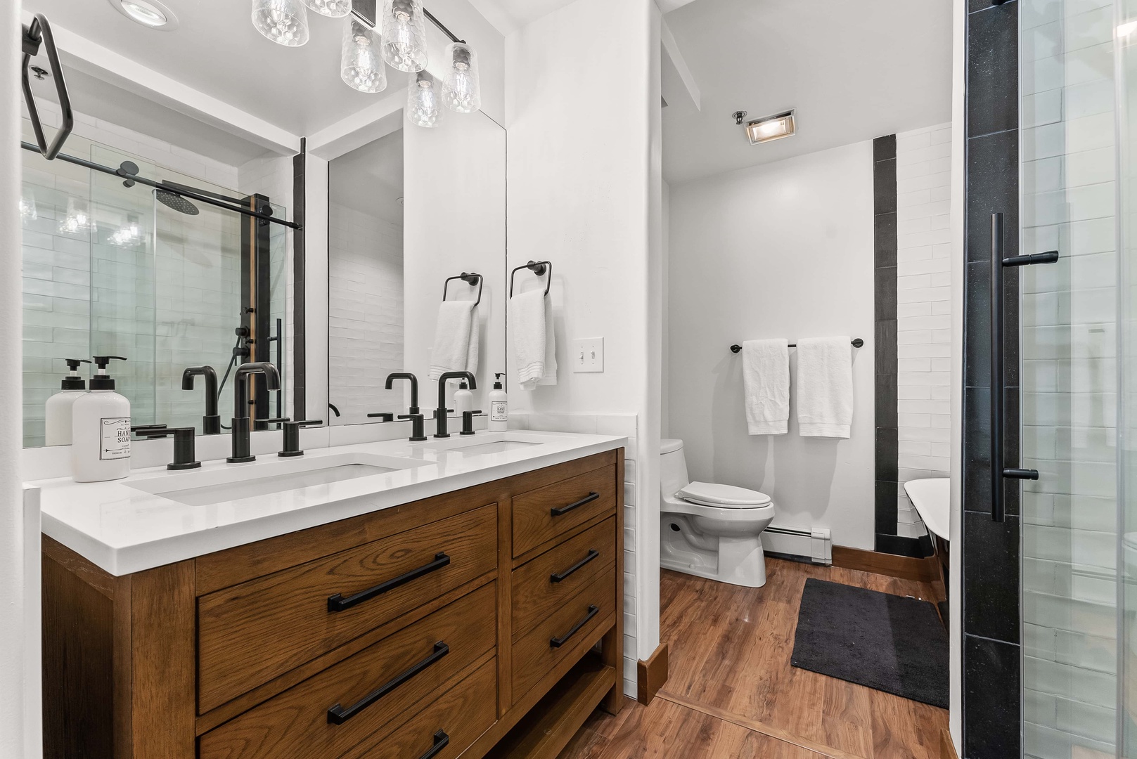 This ensuite bath offers a dual vanity, glass shower, & soaking tub