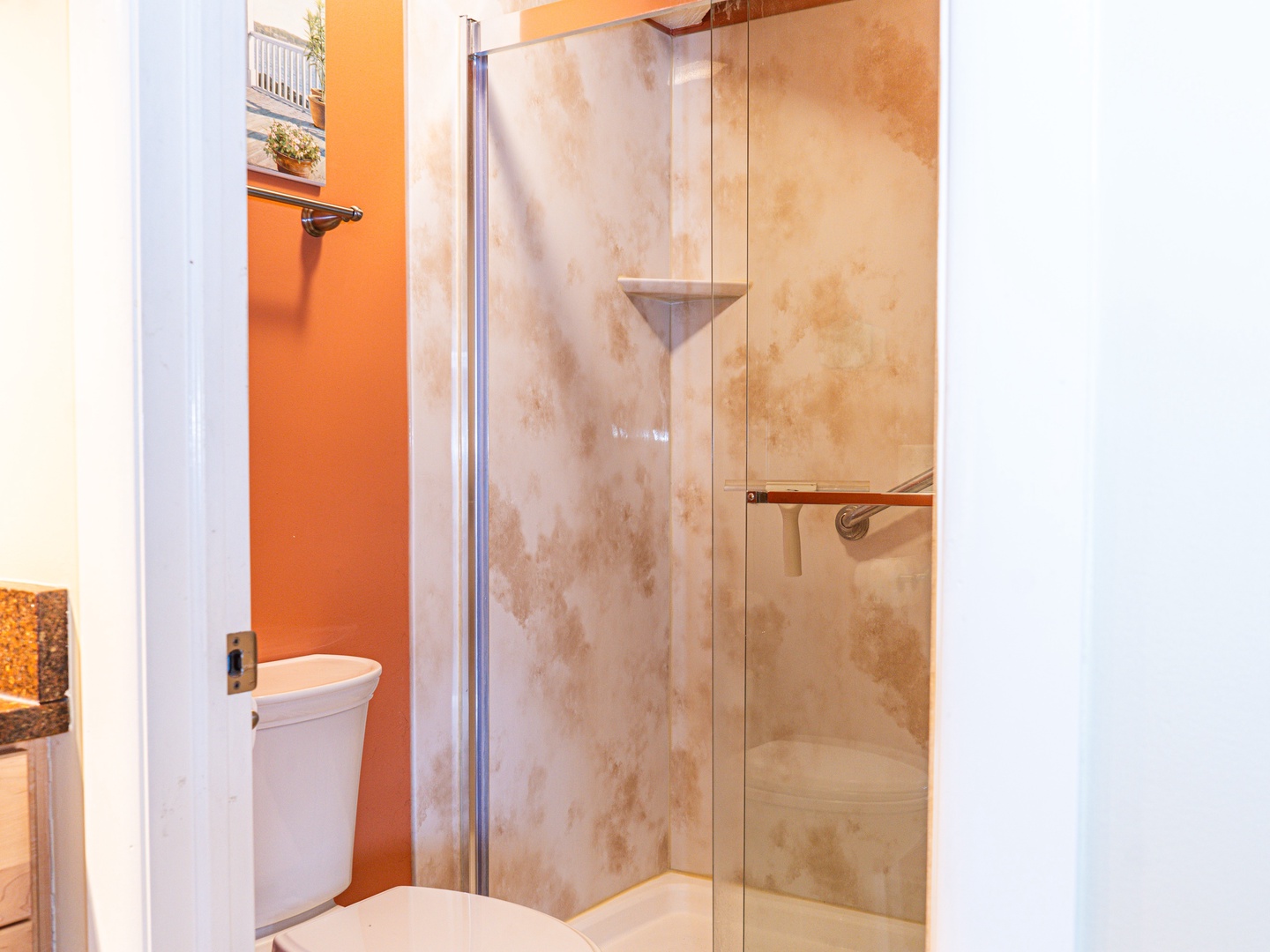 The full bathroom offers a single vanity with storage & glass shower