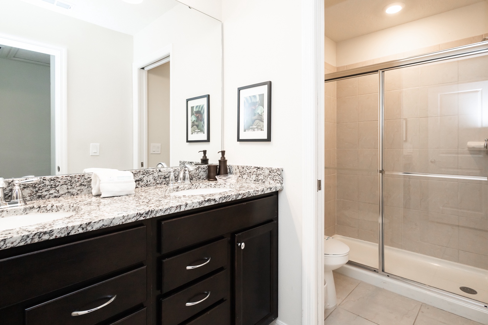 This 2nd floor hall bathroom offers a double vanity & glass shower