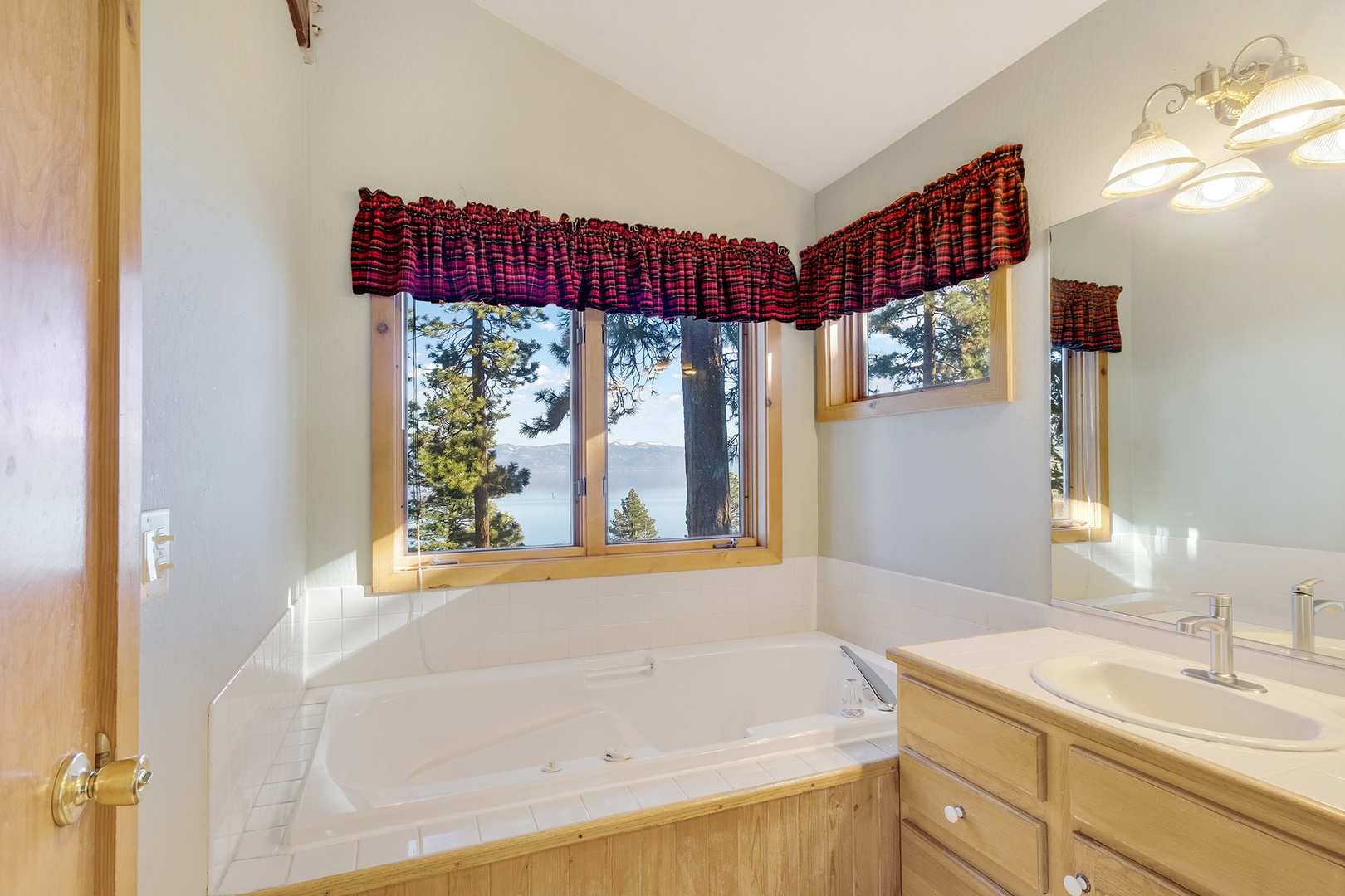 This ensuite bath features a double vanity, glass shower, and soaking tub