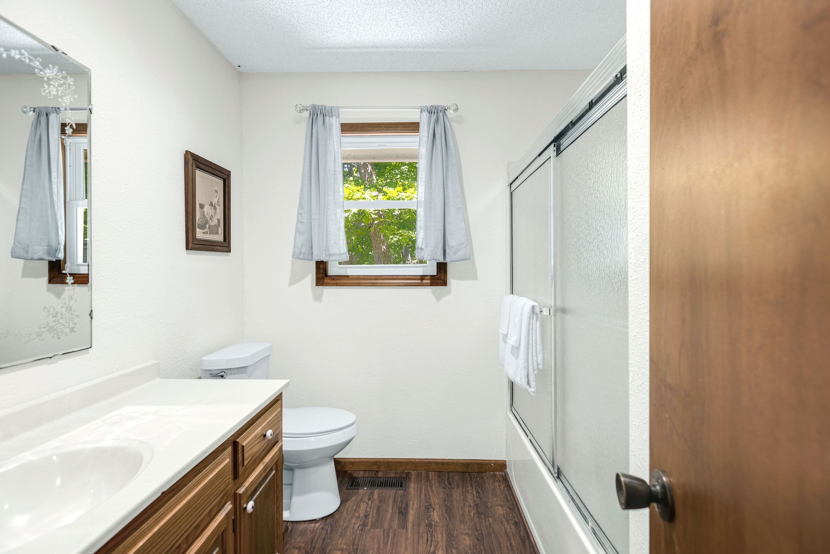 The main-level full bath offers a large vanity & shower/tub combo