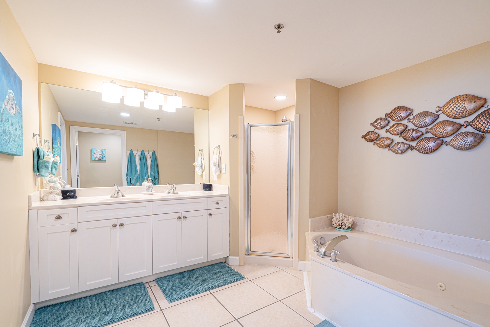 The master ensuite showcases a dual vanity, glass shower, & soaking tub