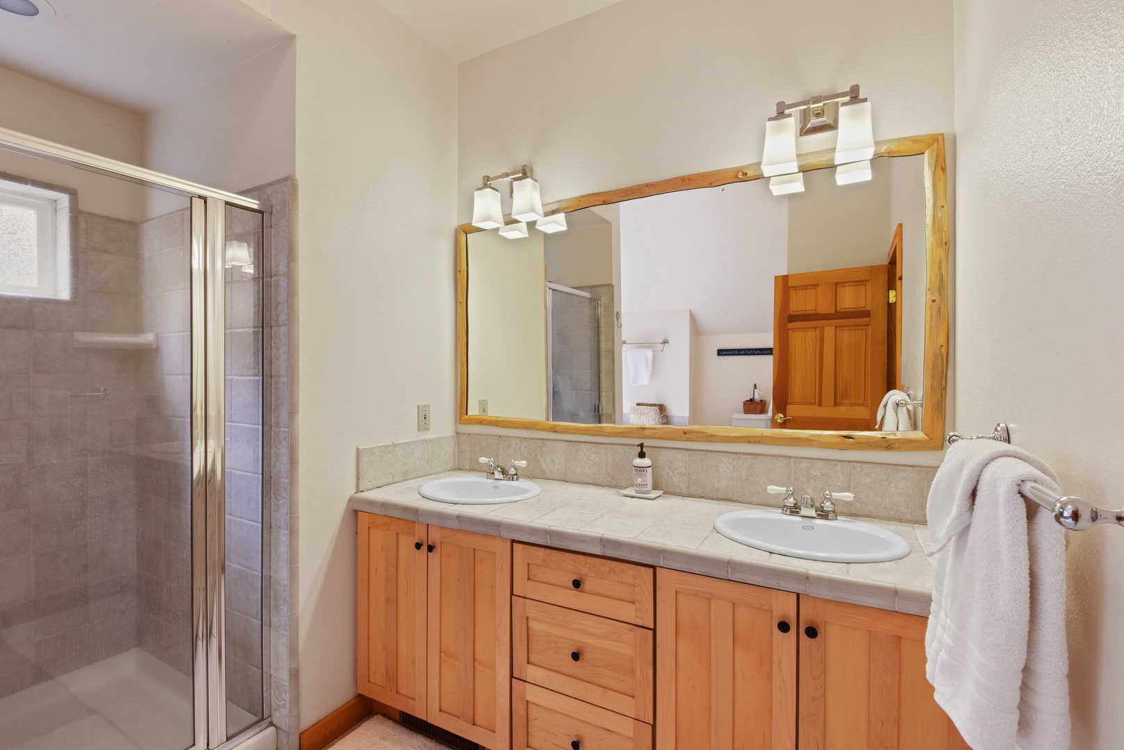 En suite bathroom with dual sinks, standing shower, and soaking tub