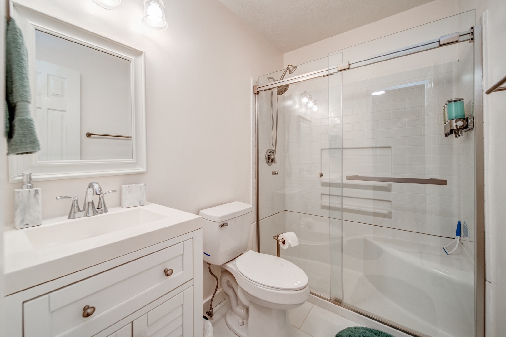 This main-level full bathroom includes a single vanity & glass shower