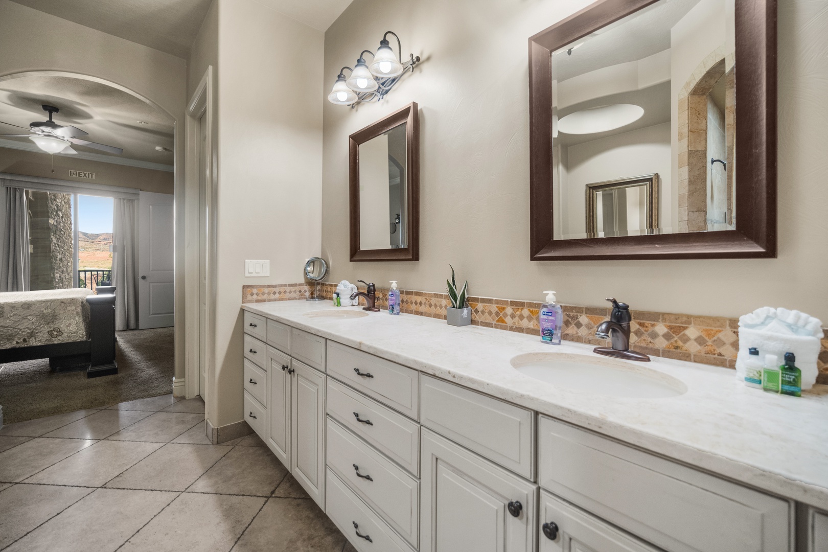 Master bathroom featuring a double vanity, spa tub, walk-in shower, and closet