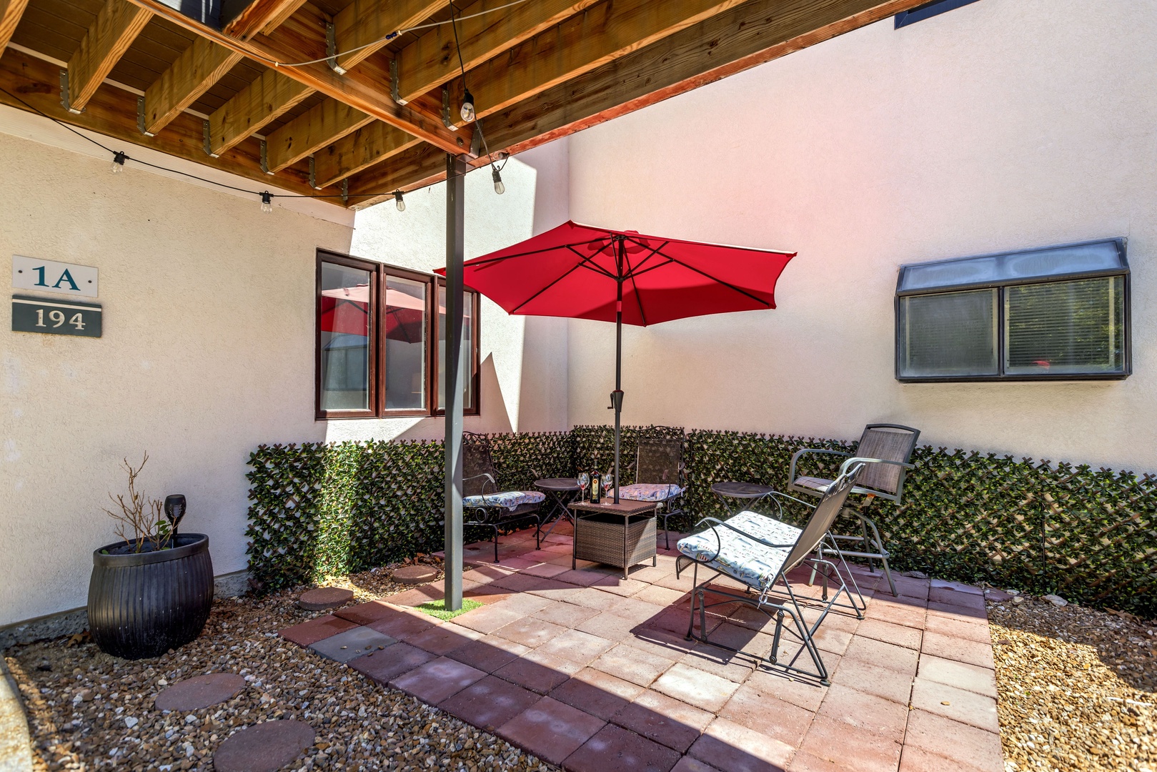 Relax on the charming porch, complete with cozy seating, umbrella, twinkling lights