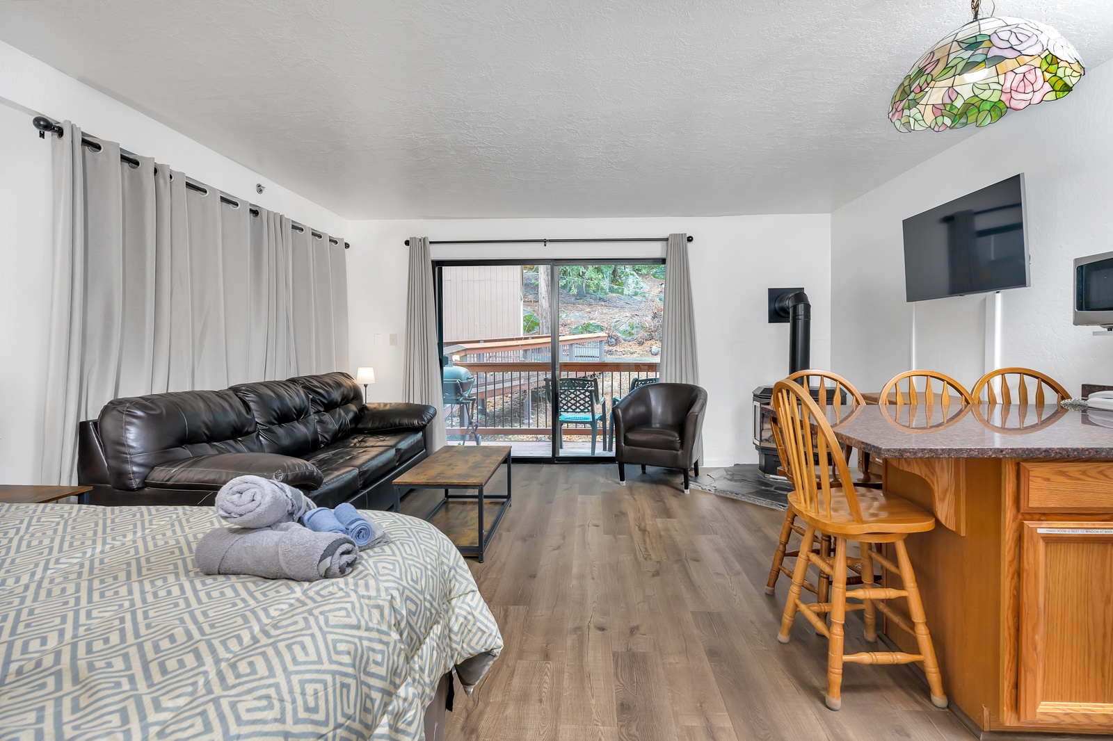 Multi-functional studio: Comfort harmonizes in bed, living, patio, & kitchen spaces