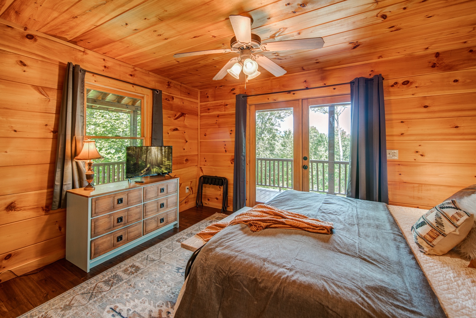 This main-level bedroom offers a king bed & access to the wraparound deck