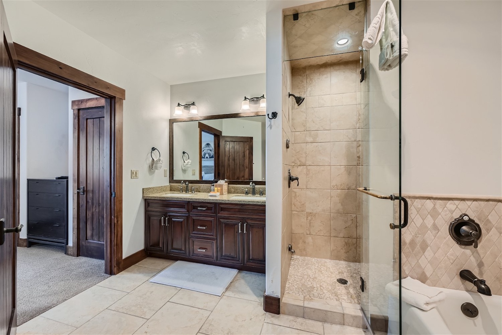 This ensuite features a double vanity, glass shower, & tub