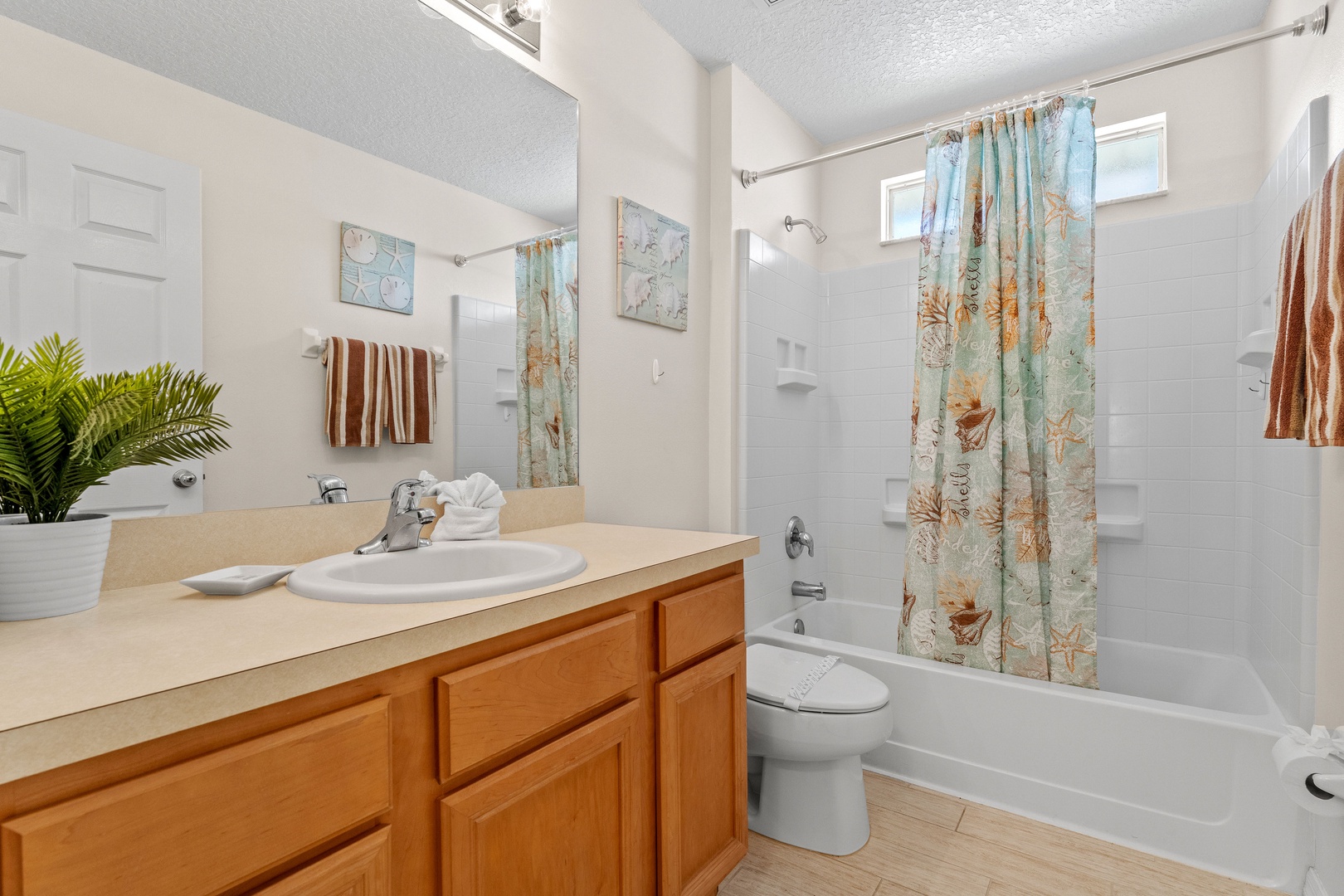 Shared full bath with oversized single vanity & shower/tub combo