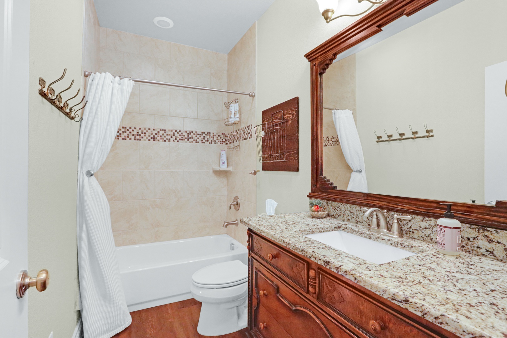 The elegant hall bath offers a single vanity & shower/tub combo