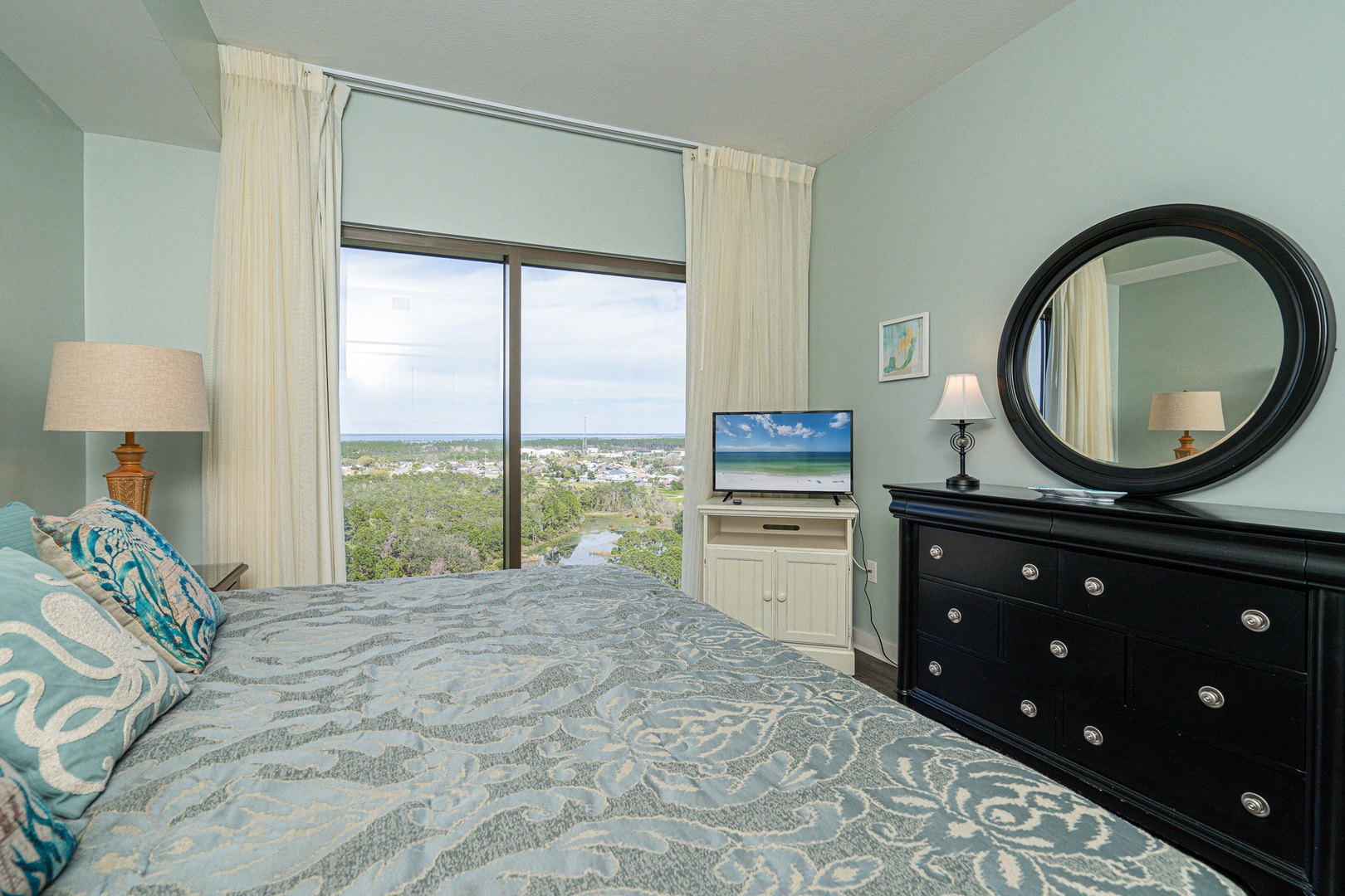 The 2nd bedroom retreat showcases a plush king bed, TV, & gorgeous views