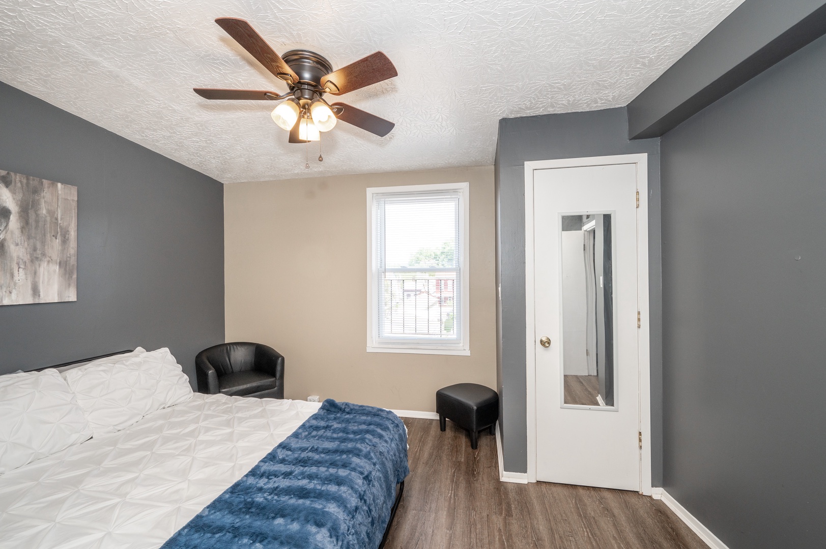 The spacious primary bedroom offers a queen bed & ceiling fan